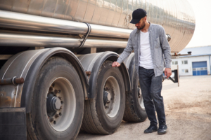 semi truck driver checking his tires
